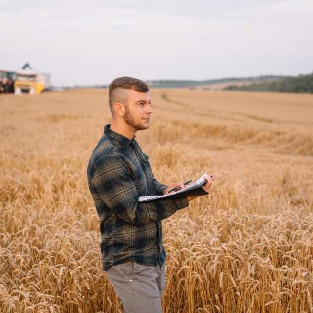 https://grupoct.com/wp-content/uploads/2024/12/young-agronomist-man-standing-wheat-field-checking-quality-while-combine-harvester-working-640x640.jpg